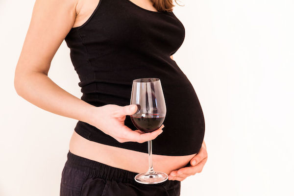 Foetal alcohol syndrome (FAS) A pregnant woman holding a glass of wine