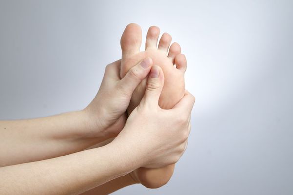 Gout A woman holding her foot in pain