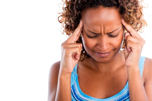 Migraine A woman holding her head in pain