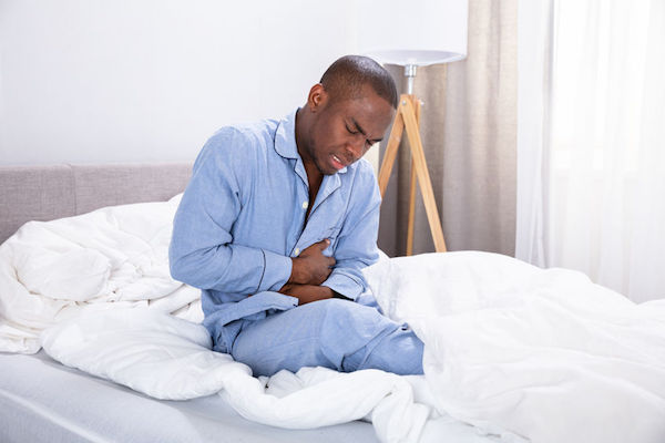 Stomach ulcer A man with a stomach ulcer in bed